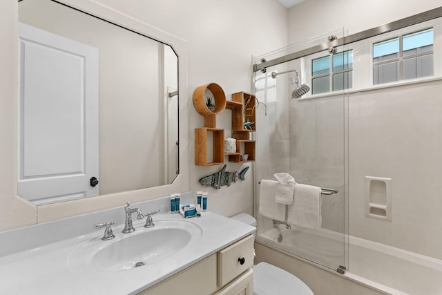 full bathroom with vanity, toilet, and combined bath / shower with glass door