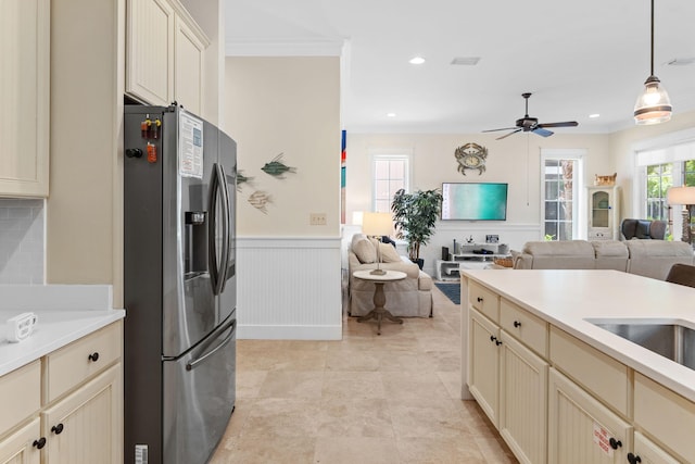 kitchen with pendant lighting, stainless steel fridge with ice dispenser, and cream cabinets