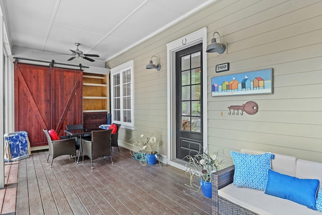 wooden terrace with ceiling fan and covered porch