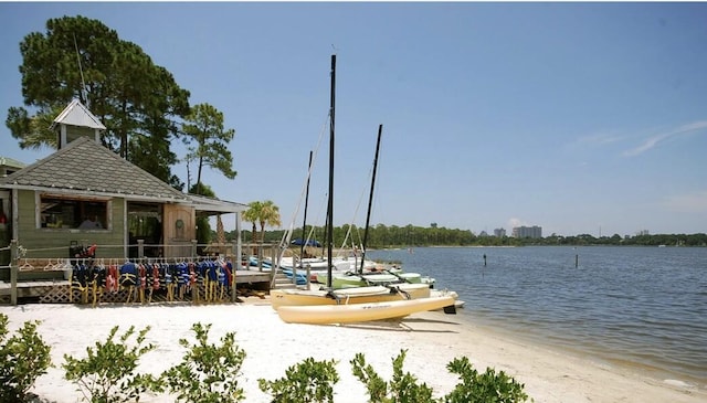 view of dock featuring a water view and a view of the beach