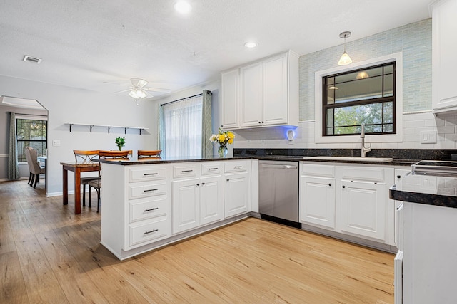 kitchen with visible vents, white cabinets, dishwasher, a peninsula, and pendant lighting