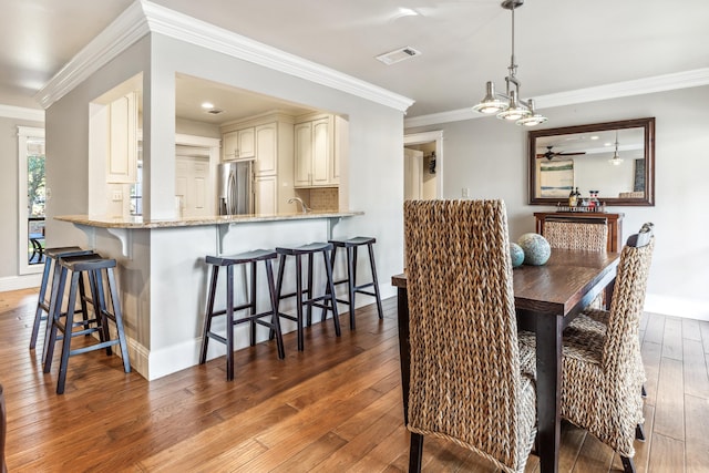 dining room with ornamental molding, ceiling fan, and dark hardwood / wood-style flooring