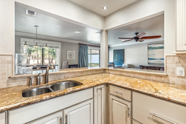 kitchen featuring crown molding, sink, decorative backsplash, and a wealth of natural light