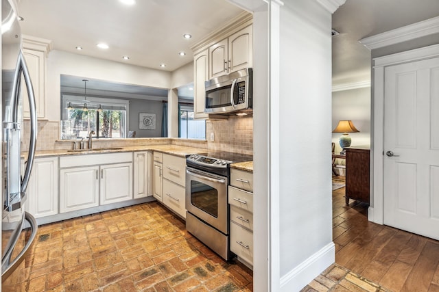 kitchen featuring tasteful backsplash, sink, ornamental molding, and appliances with stainless steel finishes