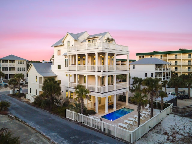 back house at dusk featuring a balcony