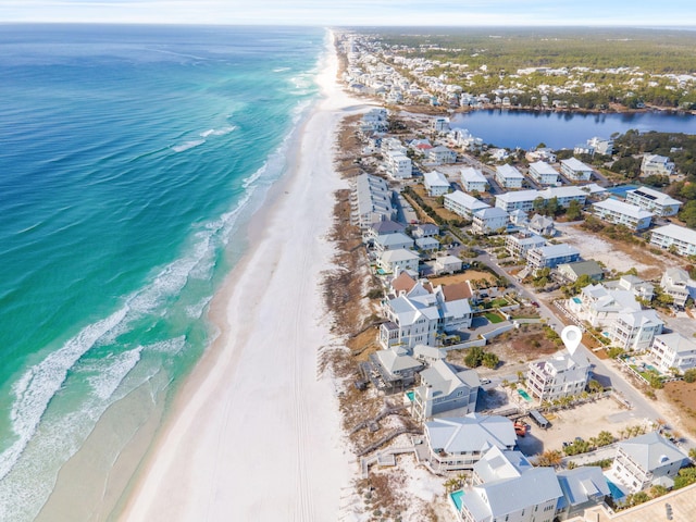 birds eye view of property featuring a water view and a beach view