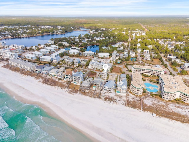 birds eye view of property with a water view and a beach view