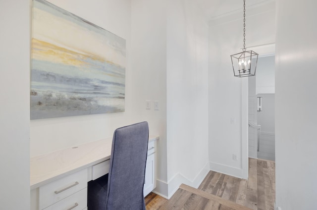 office space with built in desk and light hardwood / wood-style flooring