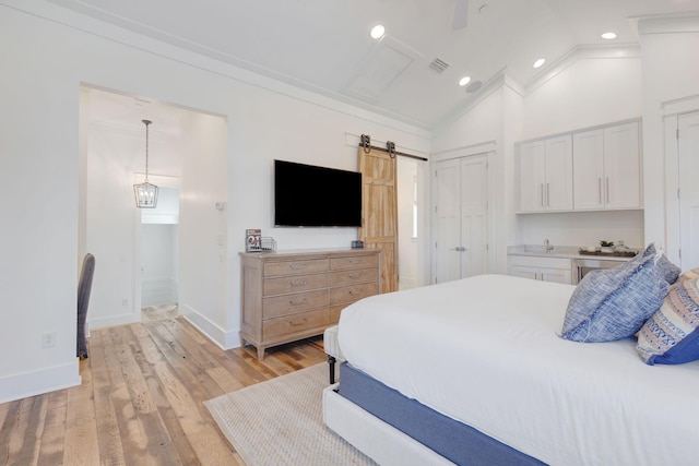 bedroom featuring vaulted ceiling, a barn door, ceiling fan, and light hardwood / wood-style flooring