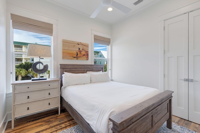 bedroom with dark wood-type flooring, a closet, and ceiling fan