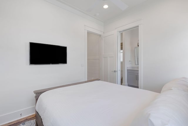 bedroom featuring crown molding, ensuite bath, ceiling fan, and hardwood / wood-style flooring