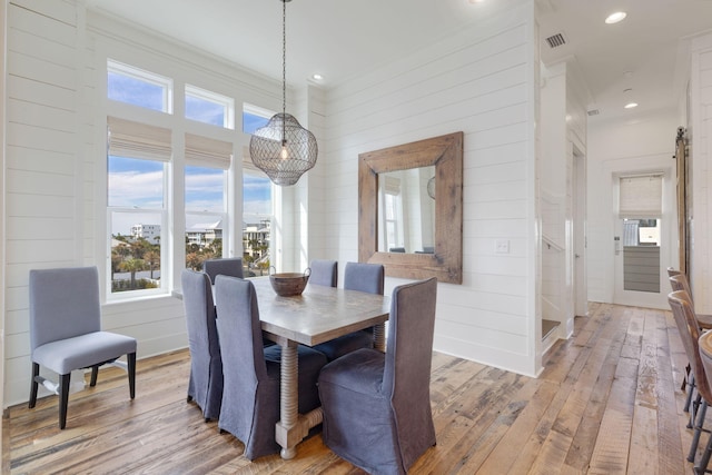 dining space featuring ornamental molding and hardwood / wood-style floors