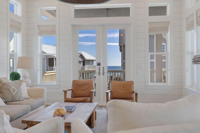 interior space with a water view and french doors