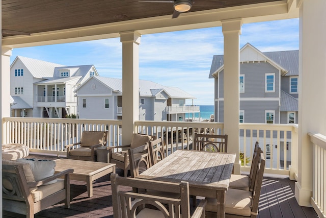 wooden deck with ceiling fan and a water view