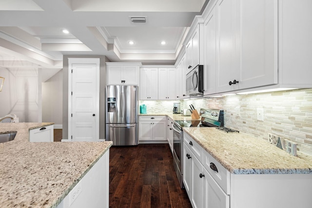 kitchen with light stone counters, dark hardwood / wood-style floors, white cabinets, stainless steel appliances, and backsplash