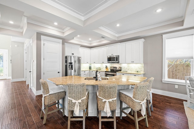 kitchen featuring appliances with stainless steel finishes, a kitchen breakfast bar, and white cabinets