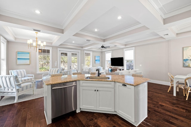 kitchen with sink, hanging light fixtures, a center island with sink, stainless steel dishwasher, and white cabinets