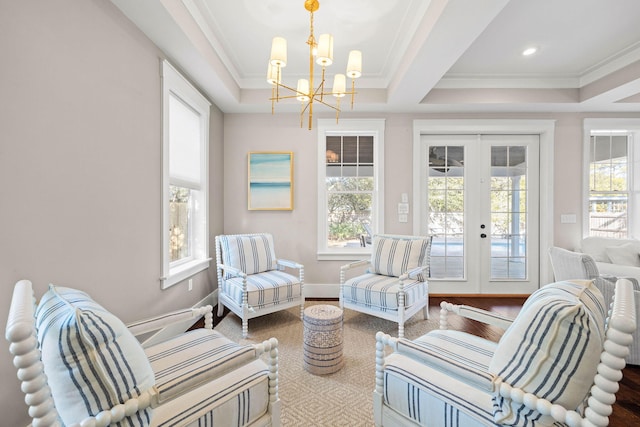 sunroom / solarium featuring french doors, a notable chandelier, a raised ceiling, and a wealth of natural light