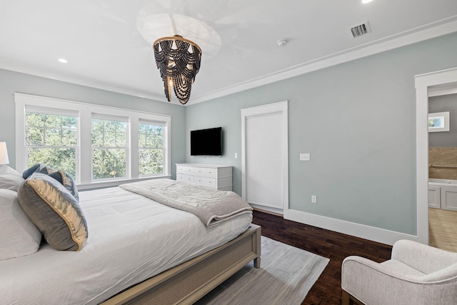 bedroom featuring dark hardwood / wood-style flooring, crown molding, and a chandelier