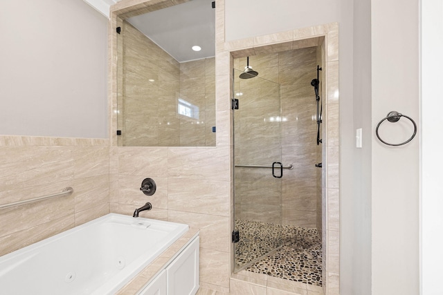 bathroom with separate shower and tub and tile walls