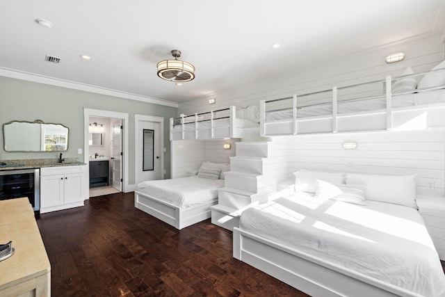 bedroom with connected bathroom, sink, ornamental molding, dark hardwood / wood-style flooring, and beverage cooler