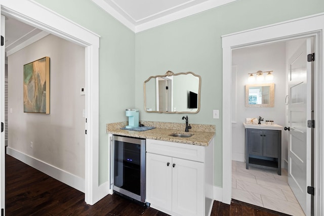 interior space with wine cooler, sink, light stone counters, dark hardwood / wood-style flooring, and white cabinets