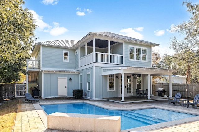 back of property featuring a fenced in pool, a patio, and a balcony