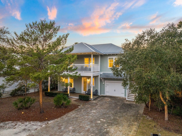 view of front of property featuring a balcony, a garage, and covered porch