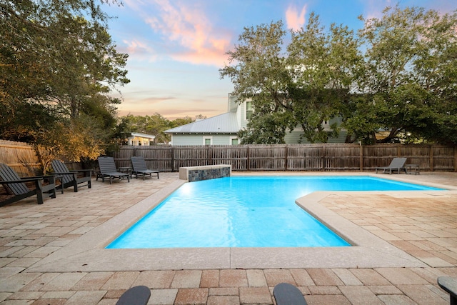 pool at dusk with a patio