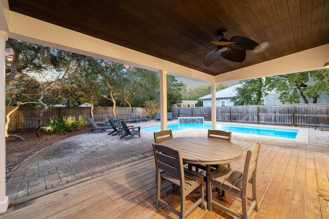 wooden deck with a fenced in pool and ceiling fan