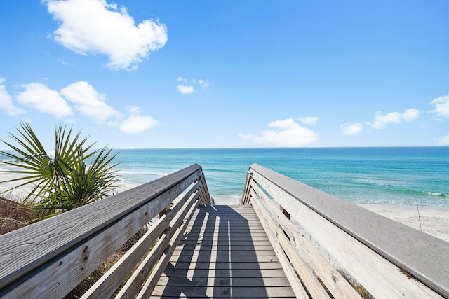 surrounding community with a water view and a beach view