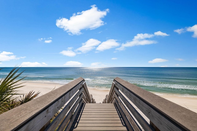 view of home's community with a water view and a beach view