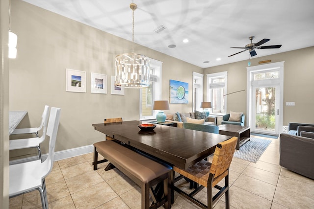 tiled dining space featuring ceiling fan with notable chandelier