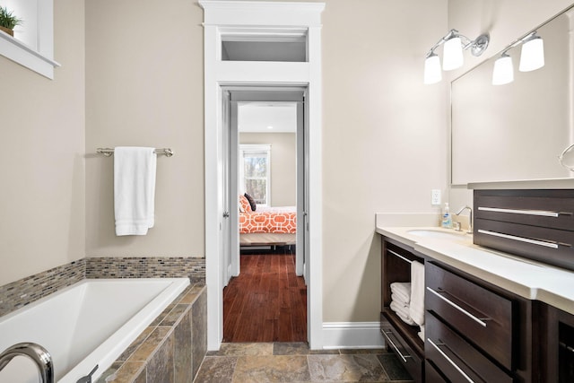 bathroom featuring vanity and tiled bath