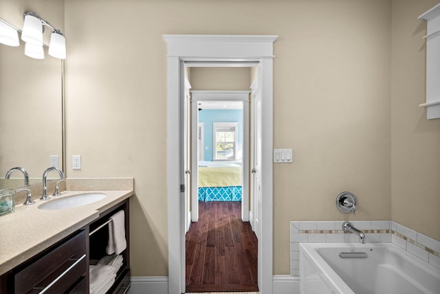 bathroom with vanity, wood-type flooring, and a washtub