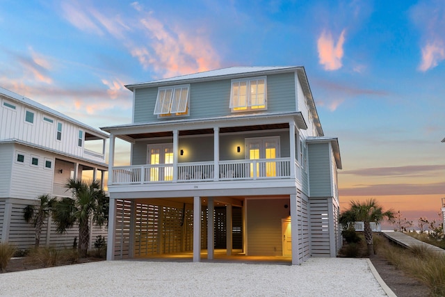 back house at dusk featuring a carport and french doors