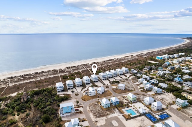 birds eye view of property with a water view and a beach view