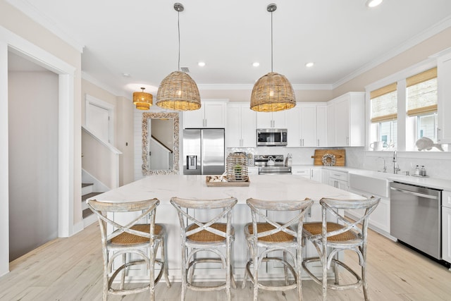 kitchen with pendant lighting, white cabinetry, appliances with stainless steel finishes, and a kitchen island