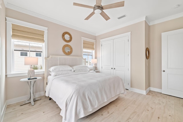 bedroom featuring multiple windows, light hardwood / wood-style flooring, and a closet