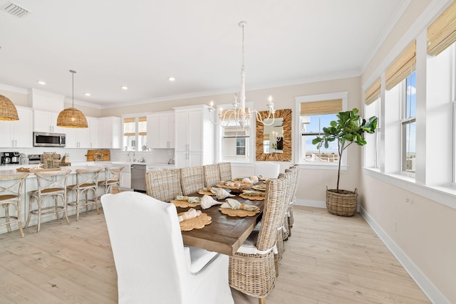 dining space with an inviting chandelier, light hardwood / wood-style flooring, and ornamental molding