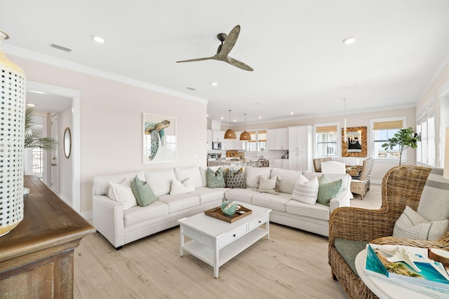 living room with crown molding, ceiling fan, and light hardwood / wood-style flooring