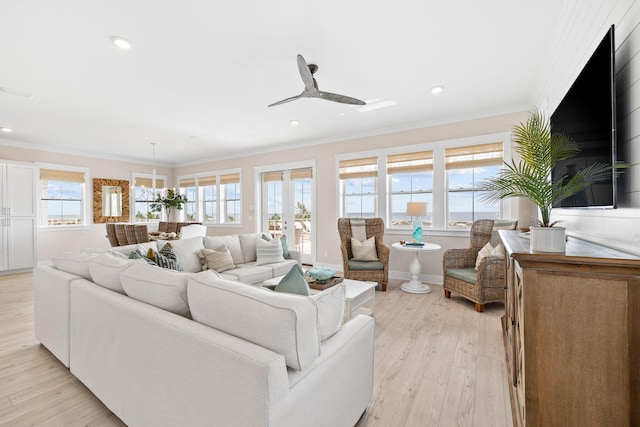 living room featuring french doors, ornamental molding, plenty of natural light, and light wood-type flooring