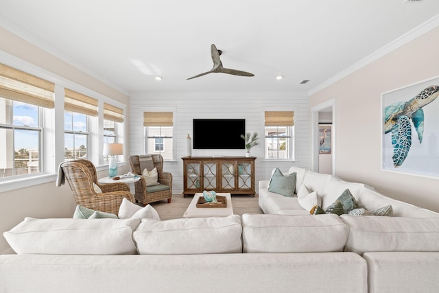 living room with crown molding, ceiling fan, plenty of natural light, and hardwood / wood-style flooring