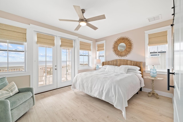 bedroom with multiple windows, access to exterior, and light hardwood / wood-style flooring