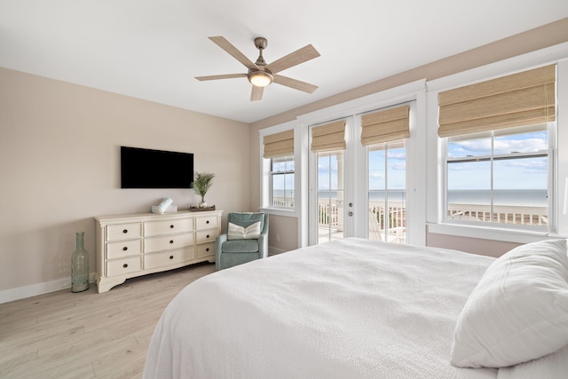 bedroom featuring ceiling fan, access to exterior, multiple windows, and light hardwood / wood-style flooring