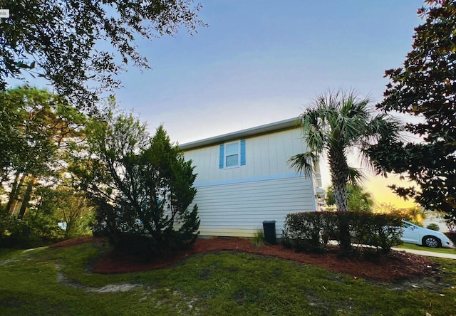 property exterior at dusk with a yard