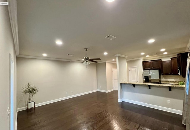 kitchen with dark brown cabinetry, a breakfast bar area, light stone counters, stainless steel fridge with ice dispenser, and dark hardwood / wood-style floors