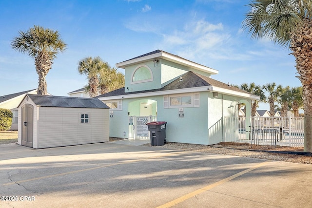 rear view of house with a storage unit