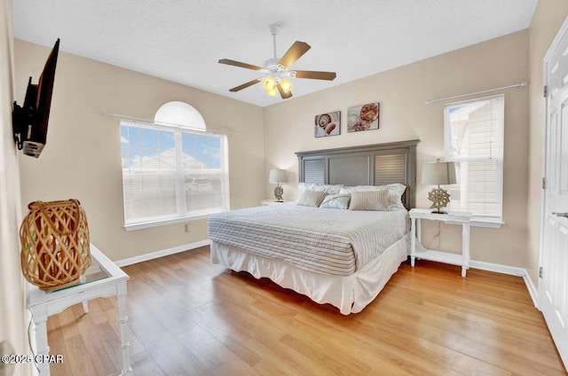 bedroom featuring ceiling fan, wood-type flooring, and a textured ceiling