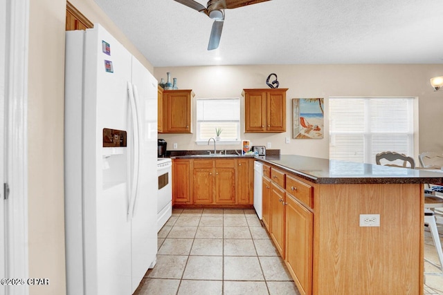 kitchen with light tile patterned flooring, sink, a breakfast bar area, kitchen peninsula, and white appliances